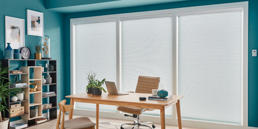 Sheer shades in a residential office diffuse light for better screen visibility. 