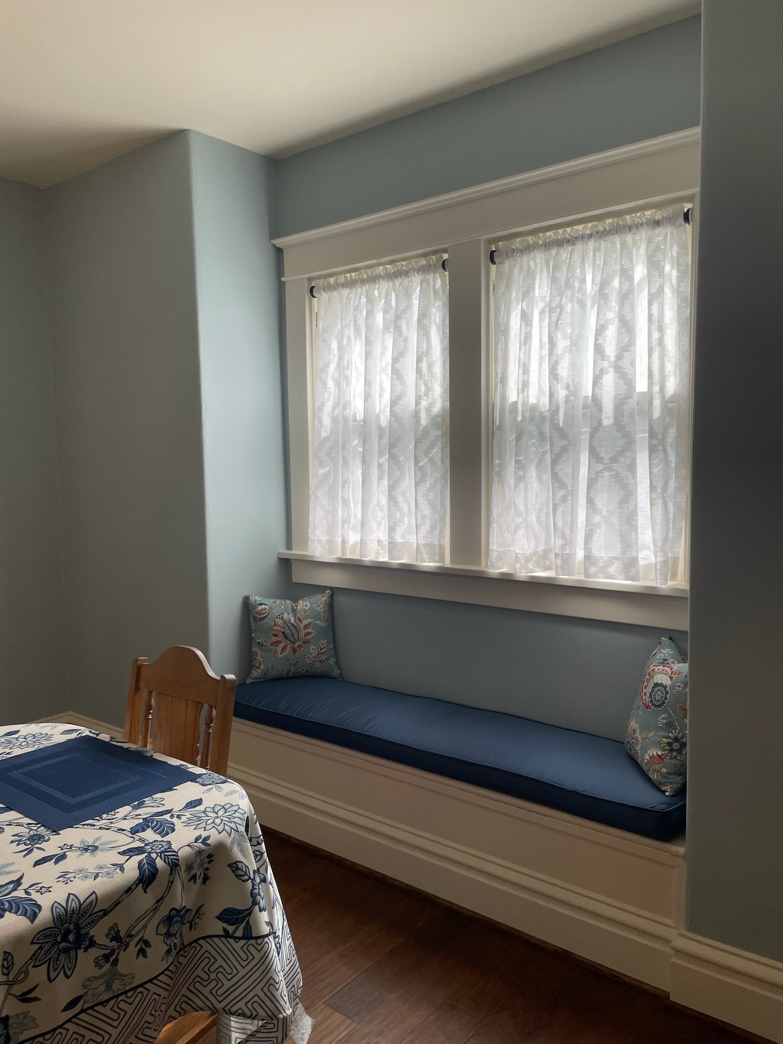 Wide view of a dining room featuring custom soft window treatments that complement the home's traditional design.