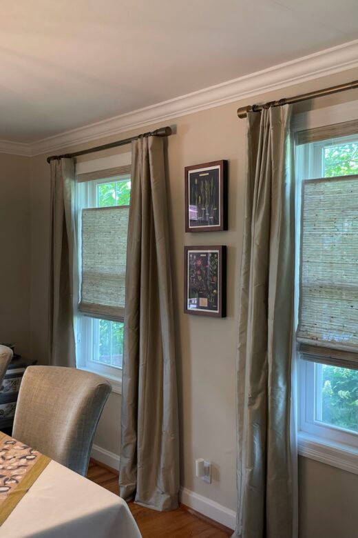 Custom woven wood shades paired with full-length drapery panels in a St. Louis dining room
