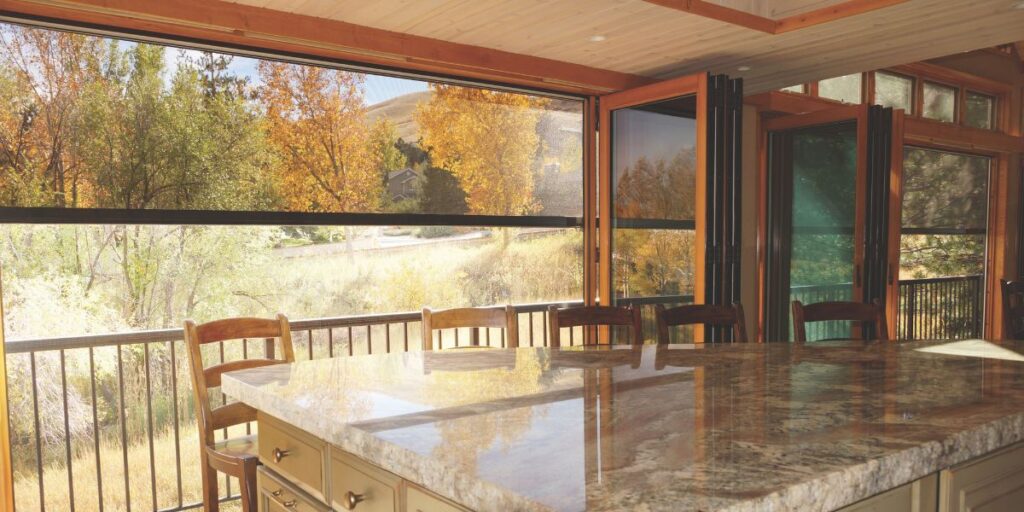 Outdoor window shades installed in a residential sunroom.