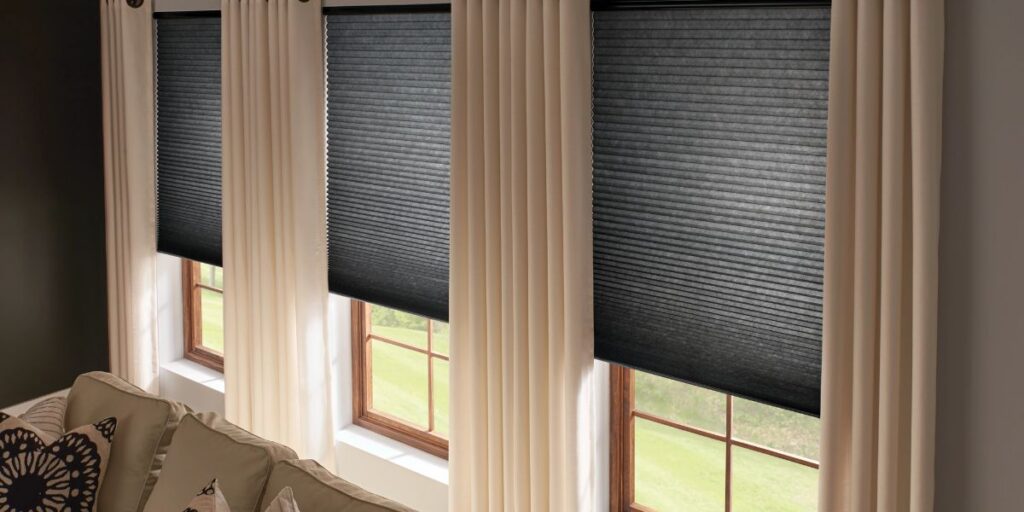 Room darkening window shades installed in a residential sitting room.