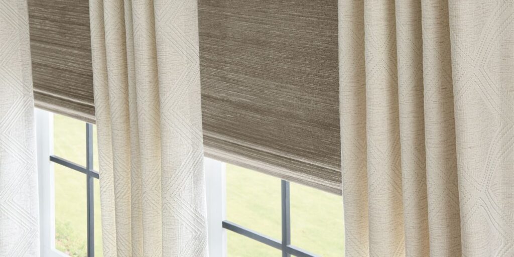 Woven shades paired with drapery over a large picture window.